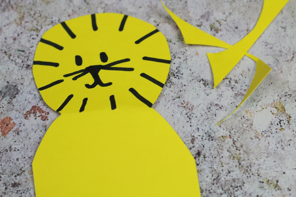 A lion head and mane drawn onto yellow card