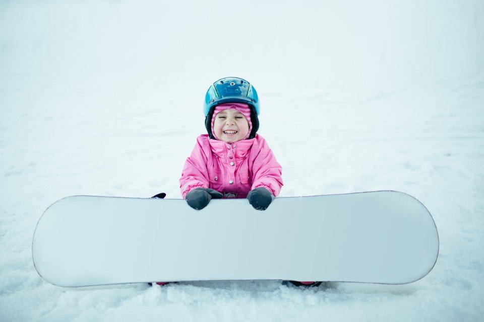 Little toddler girl with a snowboard