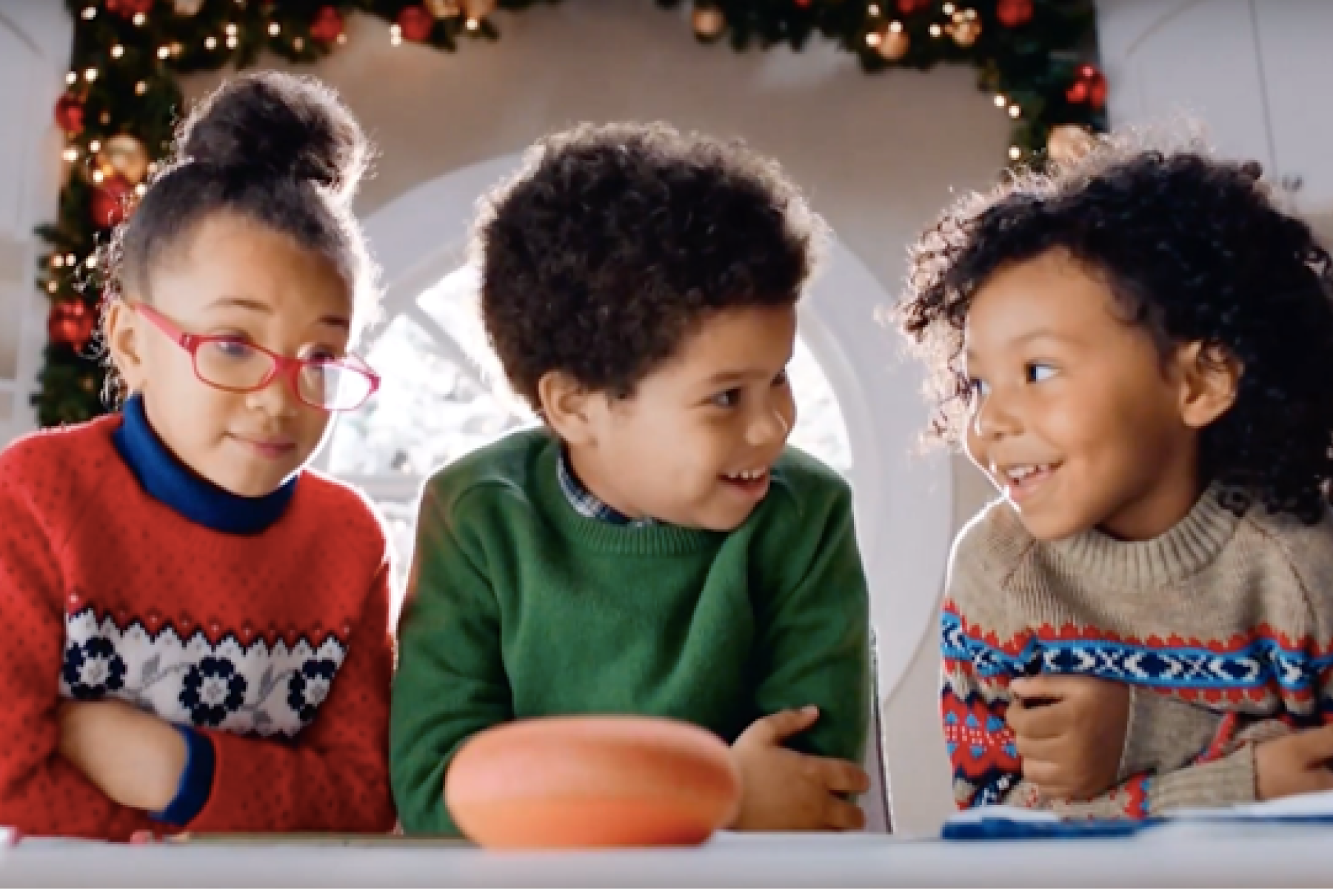 Three kids looking at their Google Nest at Christmas