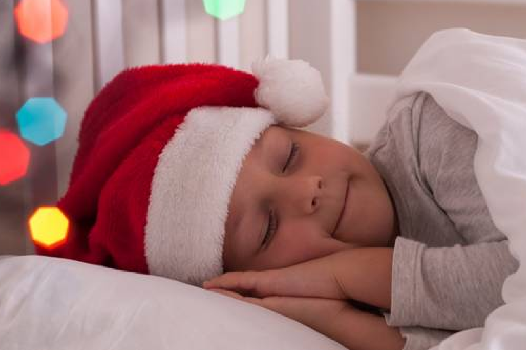 Little boy sleeping in Santa hat